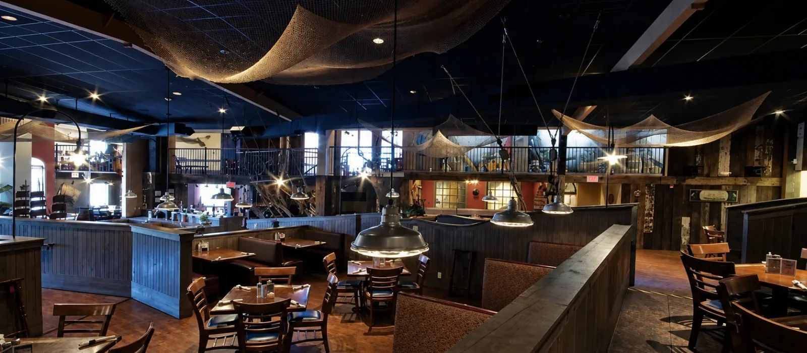 A lantern-lit dining deck under the netted ceiling